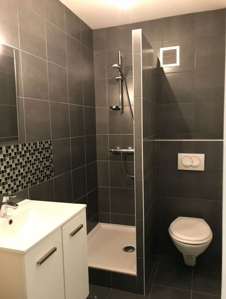 Salle d’eau carrelée avec douche, vasque et WC suspendu